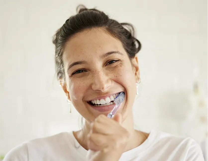 Mujer sonriendo con el cuidado dental postoperatorio